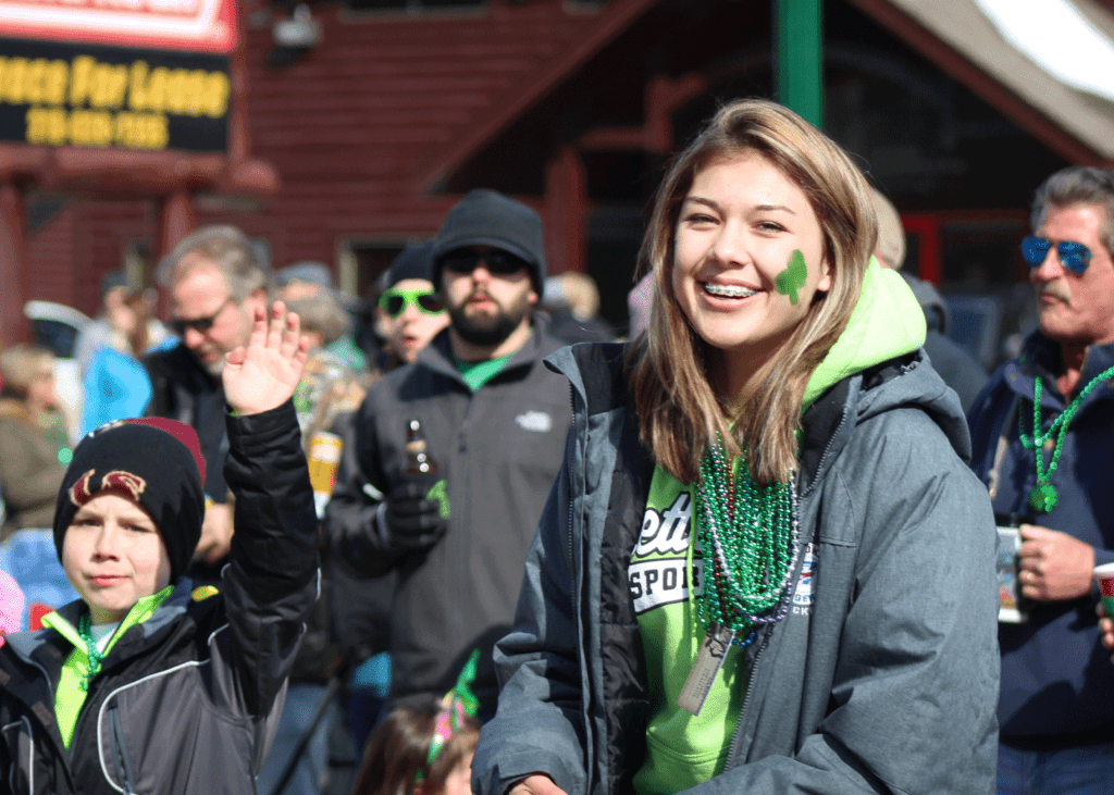 5x7 Photo of crowed of people at Crosslake St. Patrick's Day with focus on a young, smiling girl