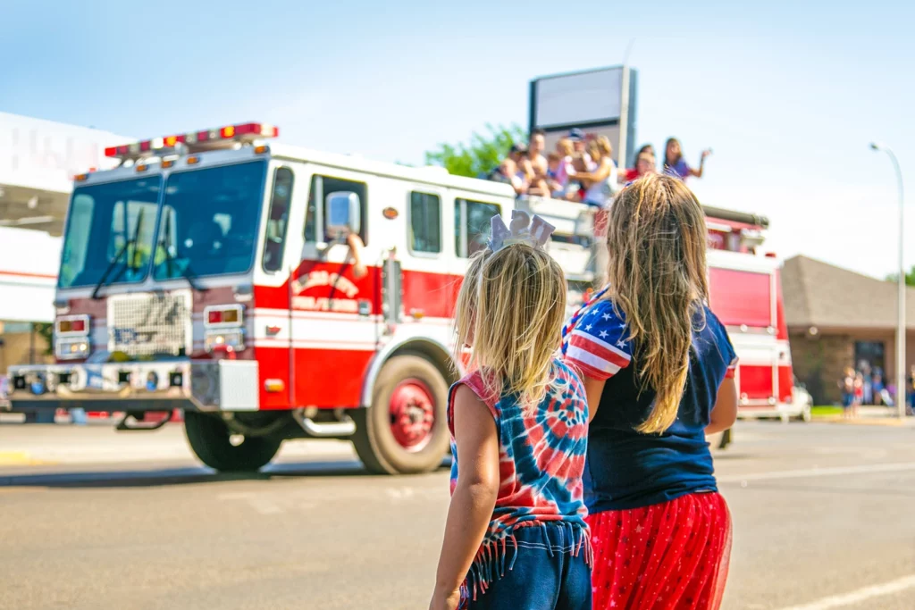 4th of July Parade photo of two girls watching a fire truck drive by
