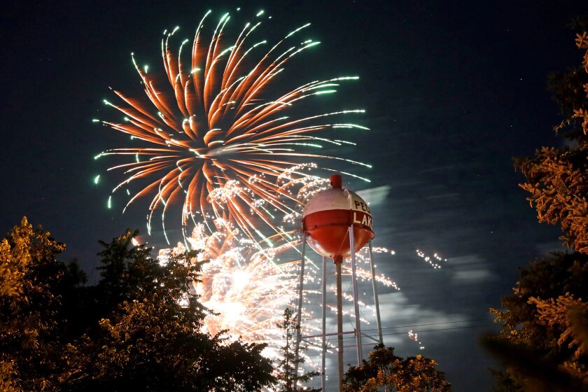 Fireworks at night behind the Pequot Lakes Bobber water tower
