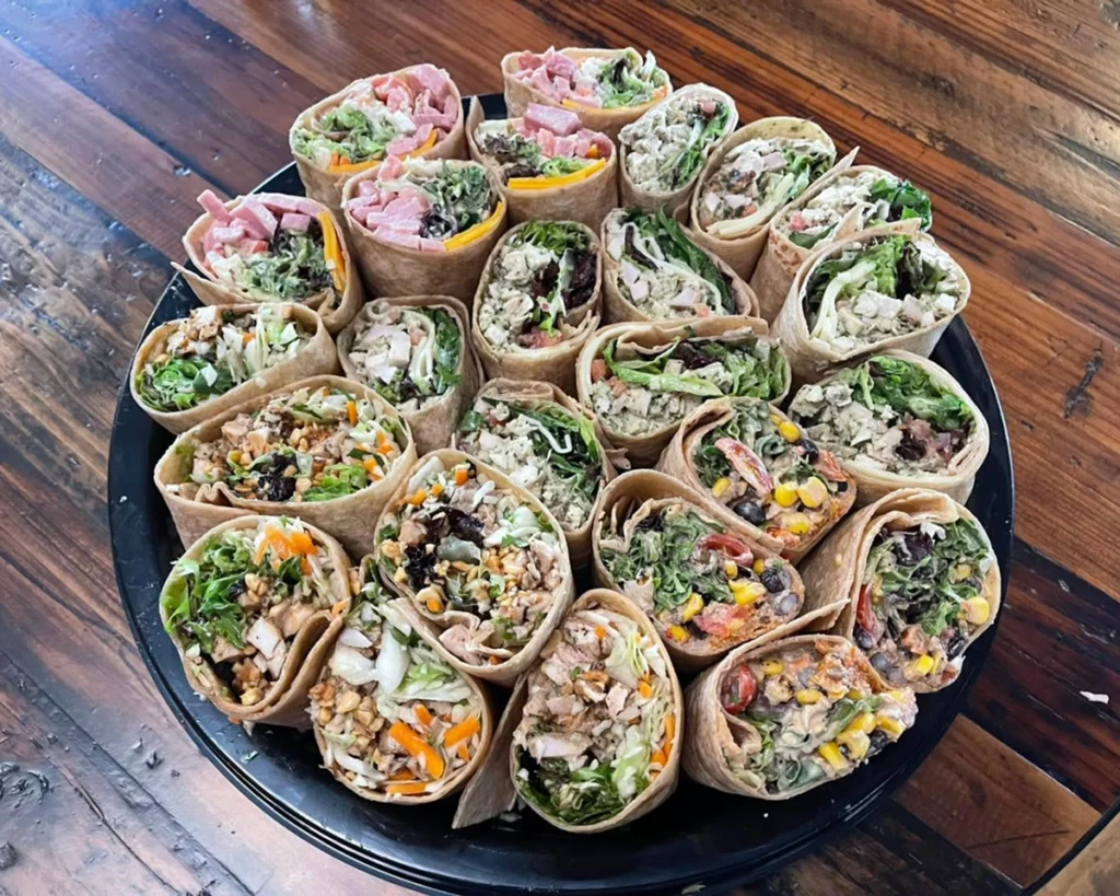 Photo of several dozen wraps on a catering dish sitting on a table in a bright dining room at Sage on Laurel copy
