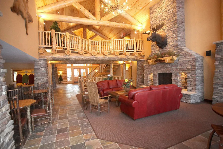 Photo of the interrior lobby at Whitefish Lodge and Suites with a large cabin aethetic and comfortable sitting area