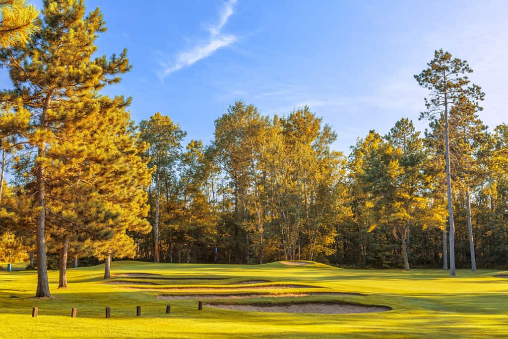 The Pines Grand View Lodge Fall Golf on a sunny day with blue skys and trees with orange leaves and green grass