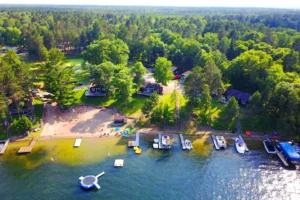 Aerial photo of Bay View Lodge resort showing the resort tucked into trees at the edge of a lake on a summer day copy