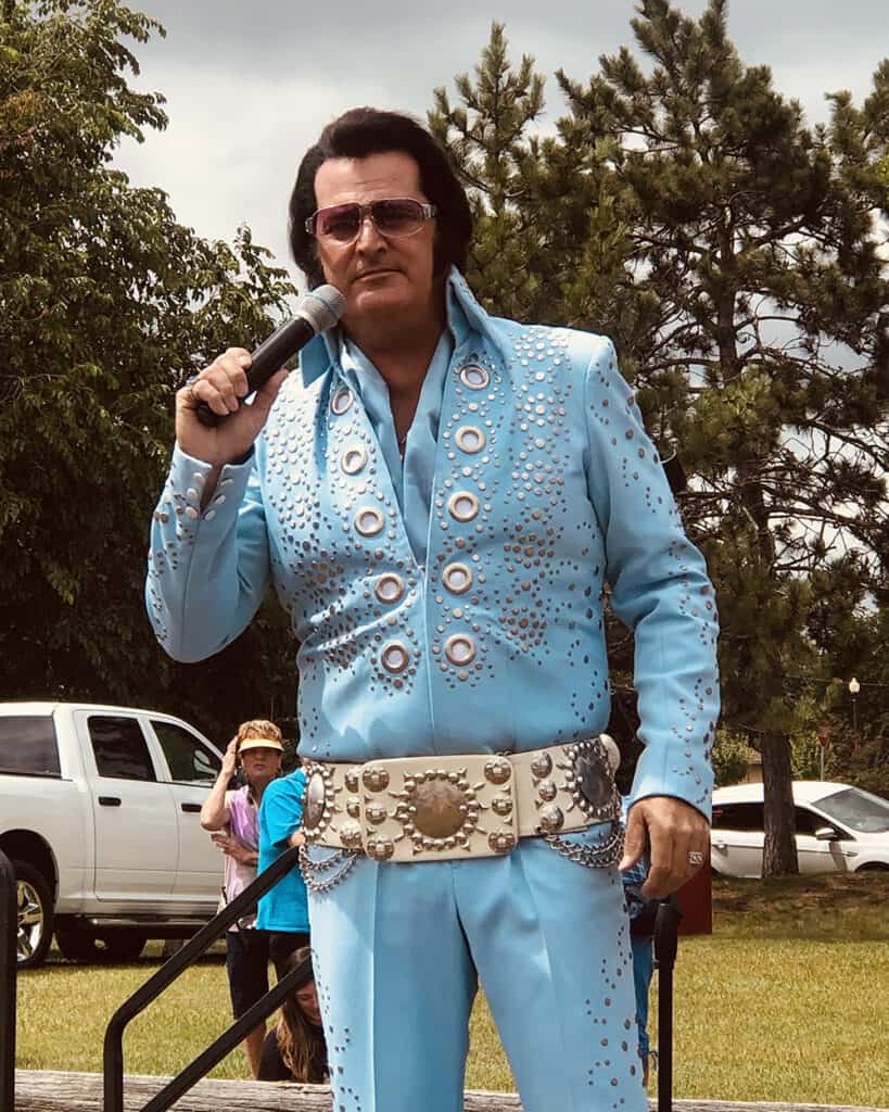Bean Hole Days in Pequot Lakes showing an Elvis lookalike dressed up and singing into a microphone