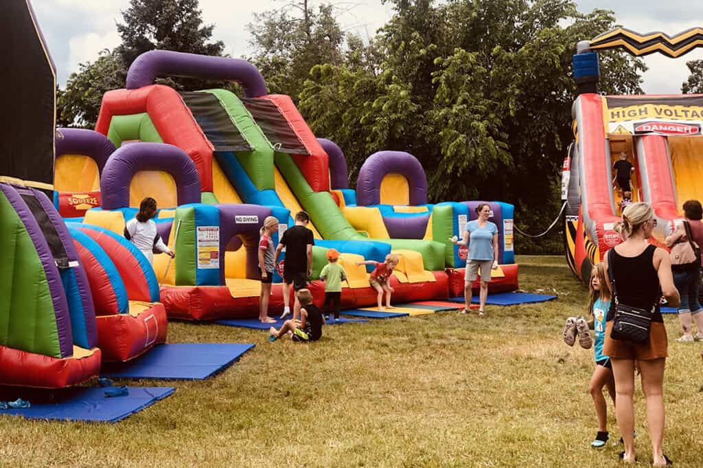 Bean Hole Days in Pequot Lakes showing kids playing on the bounce house and bounce slide